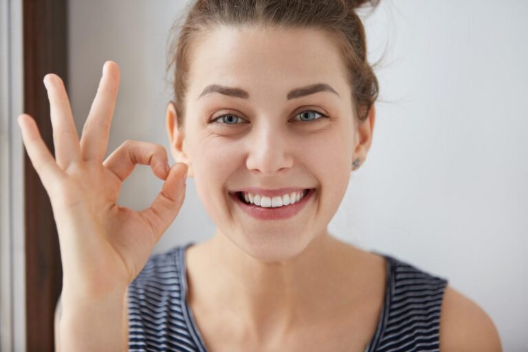 Person flossing teeth to remove plaque and maintain healthy gums