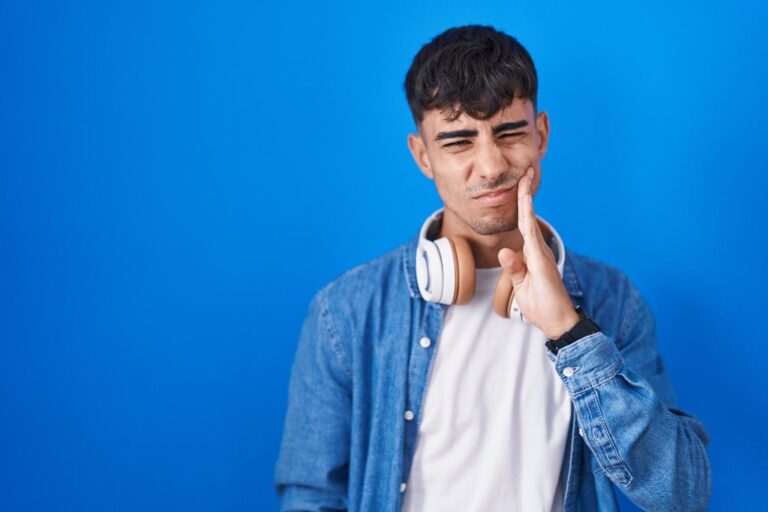 Toothache causes symptoms and treatment guide showing a person holding their painful cheek