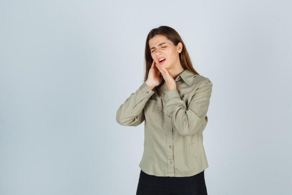 Person experiencing severe toothache with swollen cheek and jaw pain