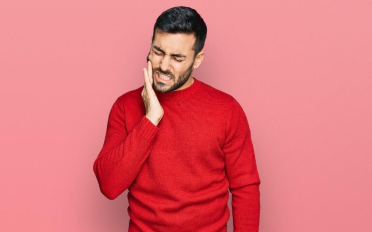 Man holding his cheek due to dental pain