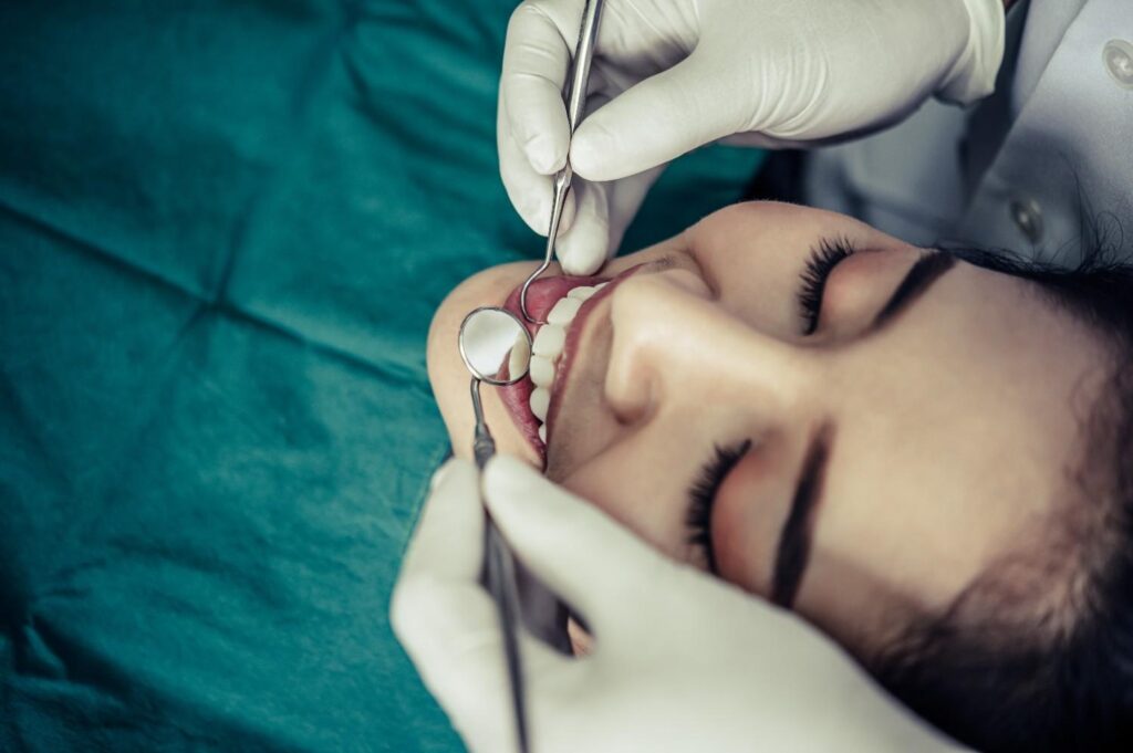 Dentist performing a gum biopsy procedure on a patient's gums during an oral examination.