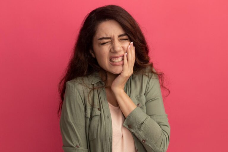 Woman holding her cheek due to severe gum pain