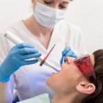 Dentist performing laser gum surgery on a patient