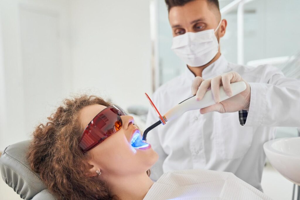 Dentist using laser treatment on a patient's gums
