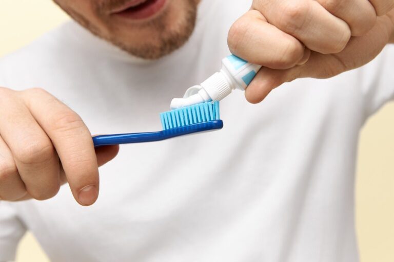 Person applying baking soda toothpaste to a toothbrush