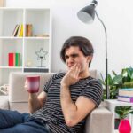 Man experiencing toothache while holding his cheek