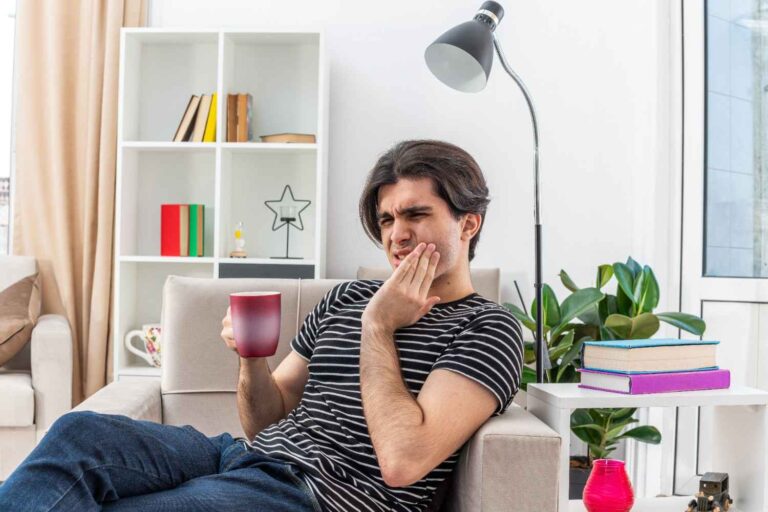 Man experiencing toothache while holding his cheek
