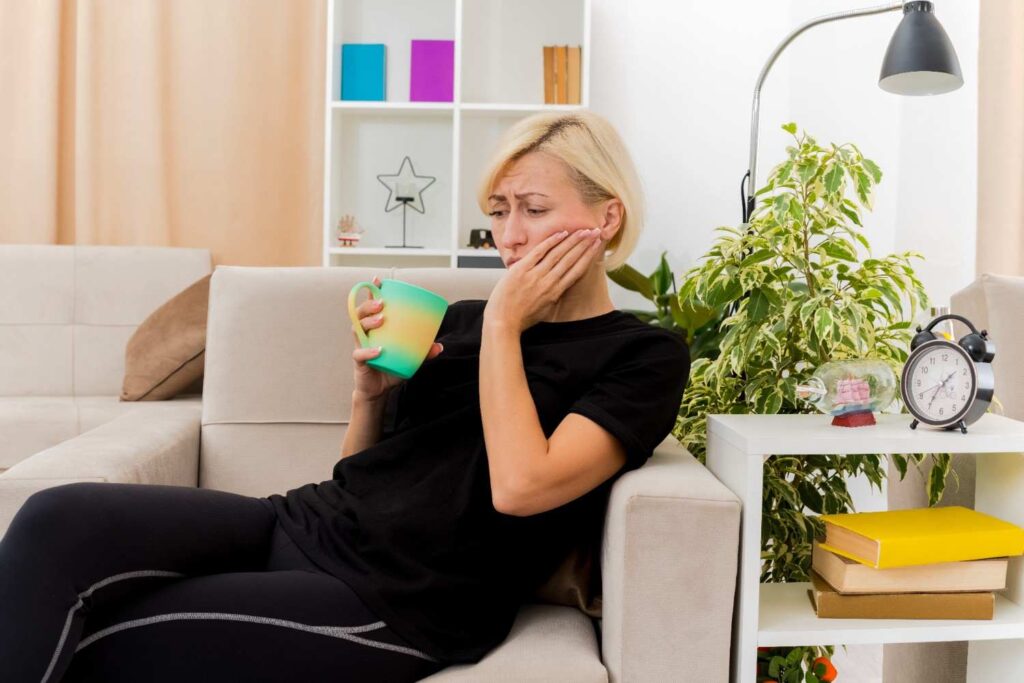 Woman experiencing toothache while holding her cheek